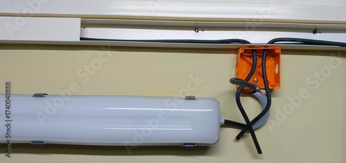  A new linear-type lamp hangs on the wall. Wires are attached to it