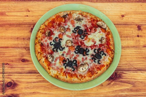 Halloween pizza with spiders and skulls on wooden table. Top view