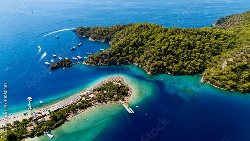 Fototapeta Naklejka Na Ścianę i Meble -  Aerial view of the Oludeniz Blue Lagoon in Fethiye, Turkey, with turquoise waters, sandy beach, forested hills, and boats, showing a popular Mediterranean travel and holiday destination.