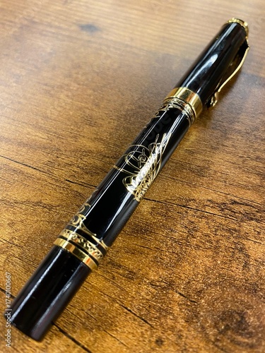 Luxury Black and Gold Fountain Pen on a Rustic Wooden Desk
