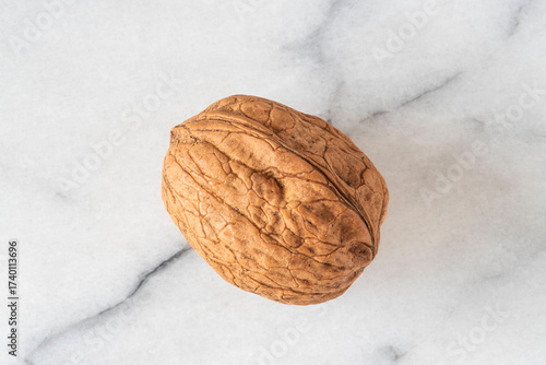 Close-up of walnuts in their shells on white marble