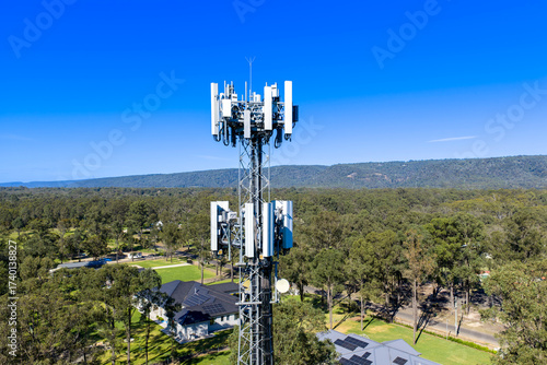 Drone aerial photograph of the top section of a large Telecommunications Tower located in a residential area amongst lush bushland in regional NSW, Australia.