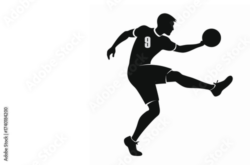 Silhouette of a football player kicking a ball