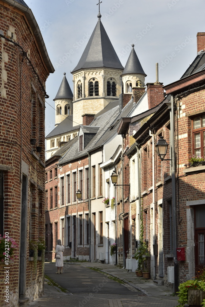 Naklejka premium L'une des rues typiques du quartier Saint Jacques et les clochers de la Collégiale Sainte Gertrude à Nivelles (Brabant Wallon)