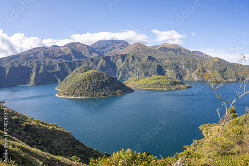 Cotacachi, Ecuador – August 5, 2025: Cuicocha Lagoon in the Ecuadorian Andes, surrounded by vegetation. In the background, the majestic Cotacachi Volcano with its summit hidden among the clouds.