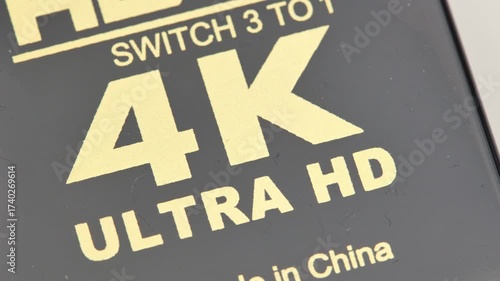 Macro closeup of a generic 4k UHD video logo symbol on electronic equipment, capture card monitor, high resolution abstract concept, no people, 4k hi res material icon on device surface up close