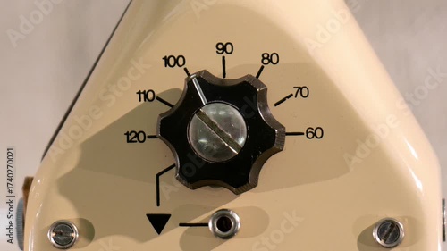 Macro closeup of vintage retro analog dial knob on old generic electronic device machine equipment panel, turned to 100, worn scale markings, industrial mechanical control, device interface, nobody