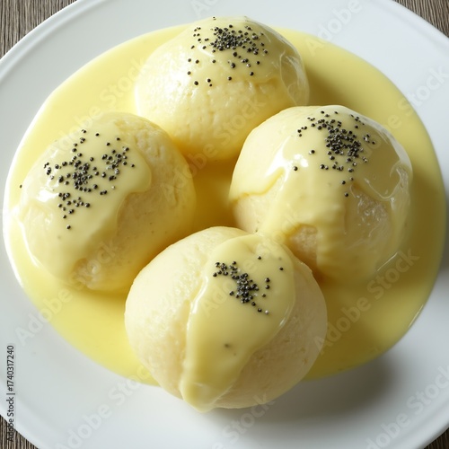 Warm and comforting Dampfnudeln, a plate of sweet steamed dumplings, generously drizzled with vanilla sauce and sprinkled with poppy seeds, offering a delightful treat.