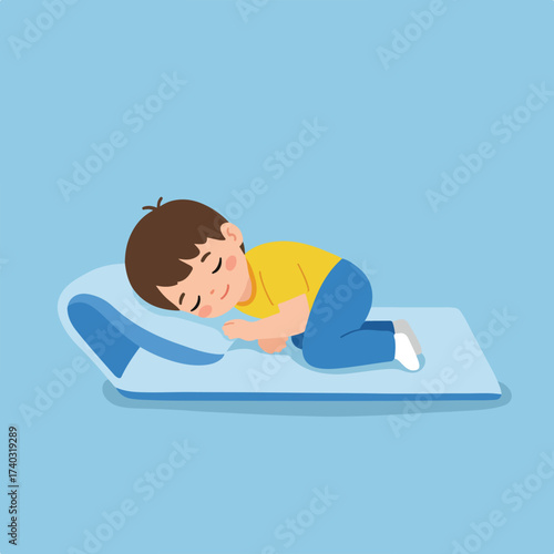 A young child sleeping peacefully on a blue mat and pillow