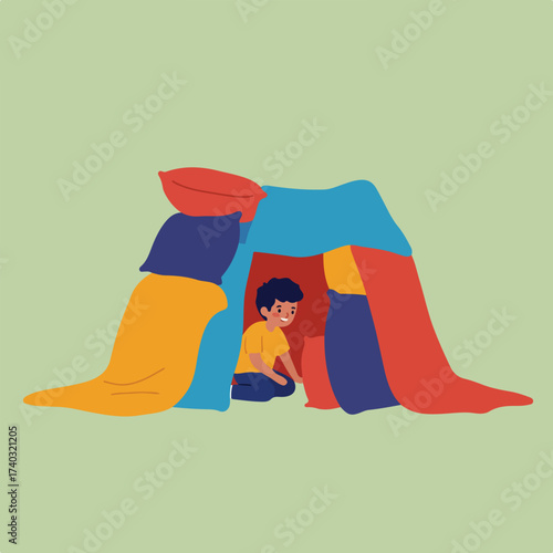 A young boy plays inside a colorful blanket fort constructed with pillows
