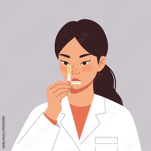 Woman in lab coat intently examines test strip with yellow markings