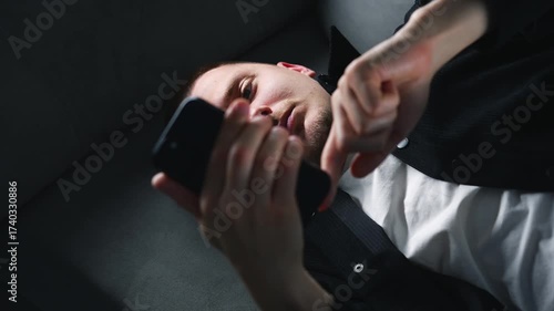 A businessman holding a smartphone on a sofa in a dark room.
A man taps his finger on a touchscreen phone.
A man uses a smartphone for online communication.
Smartphone, communication, messaging