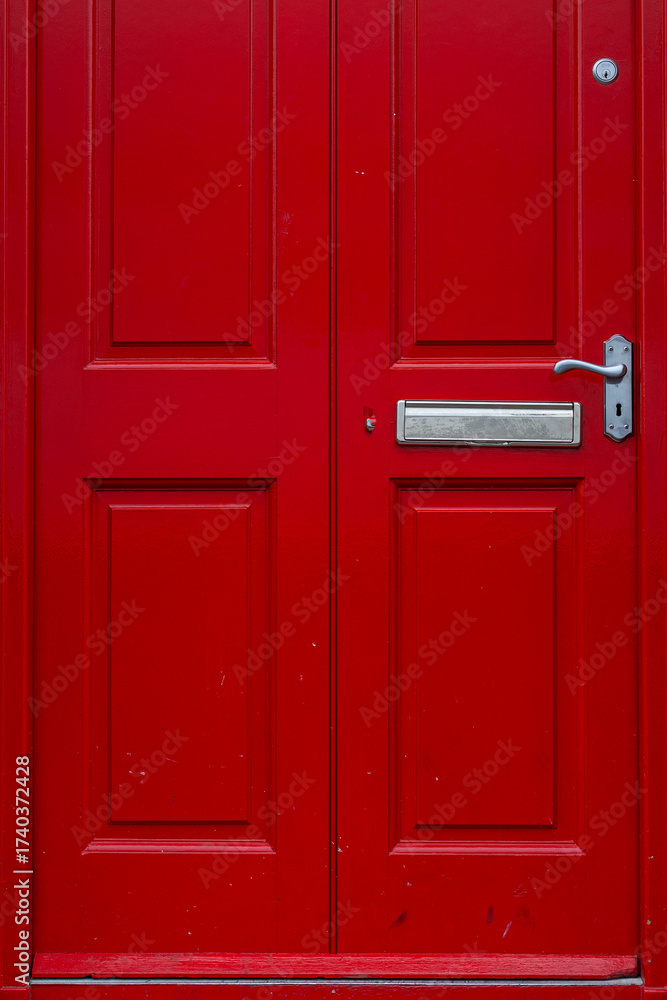 Fototapeta premium Colorful red door and the doorstep, the symbol of the city, in the center of Dublin in Respublic Ireland