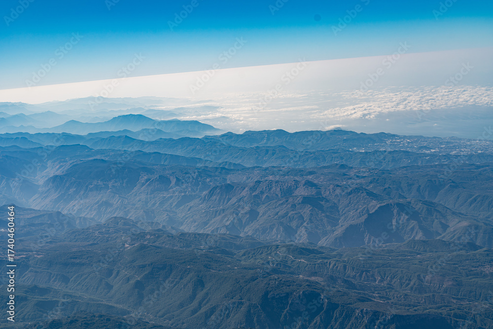 Fototapeta premium Aerial View of Rugged Desert Mountain Range with Dramatic Peaks and Valleys