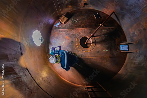 Male worker inspection floor scan tank oil of rust wall, loss of thickness bottom plate in the manhole tank to work inside