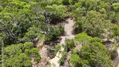 aerial drone shot of 4x4 offroad vehicle crossing the iconic gun shot creek along the old telegraph track in the outback of cape york, a popular travel destination in Queensland, Australia.