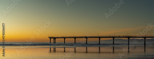 Panorama of pier during sunrise on beach 