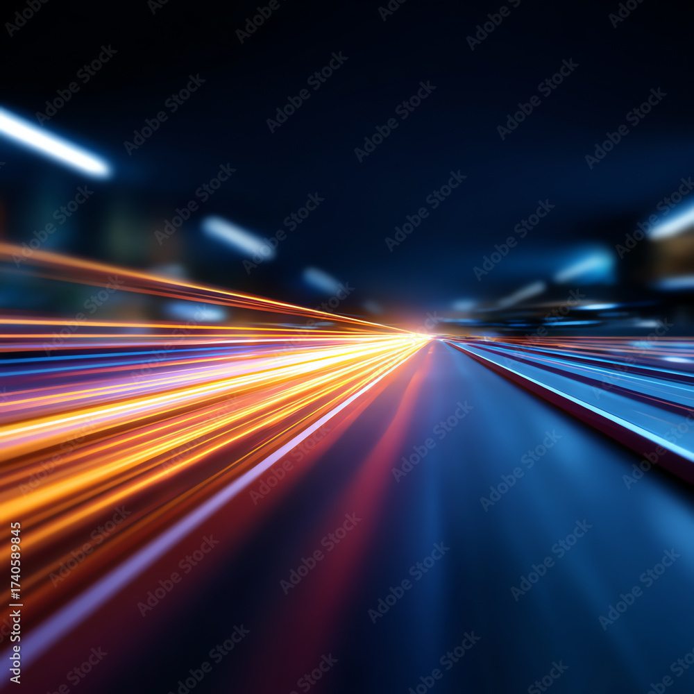 Fototapeta premium Blurred streaks of orange, yellow, and blue light create a dynamic sense of speed and motion against a dark background, resembling fast-moving traffic or futuristic light trails