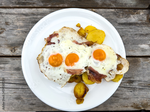 Delicious traditional Tyrolean mountain dish with cut grilled potatoes, speck and eggs. View from the top. Calorie dish