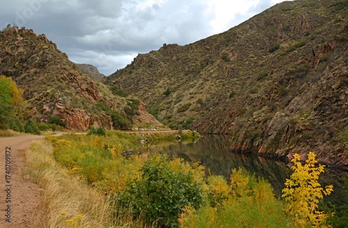 Beautiful early  fall scene with a mountain backdrop  on a stormy day,  next to the south platte river  in  waterton canyon, littleton, colorado 