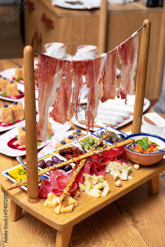 Antipasti in the restaurant, exquisite serving of meat appetizers, jamon, ham, salami, olives, sauce