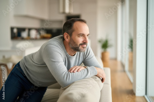 A man on a couch gazing out the window