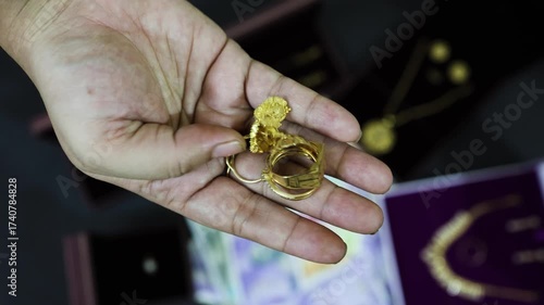 Adult Hand Holding depicting Indian Cultural Gift Of Gold Ring And Wealth