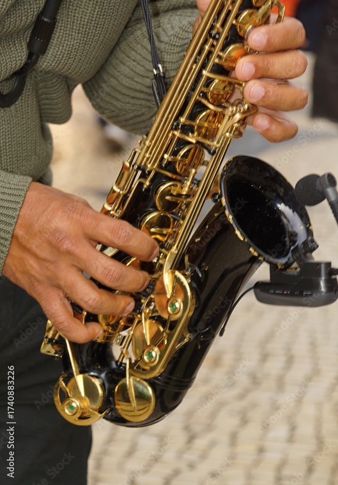 Obraz premium Musician playing black and gold saxophone during performance