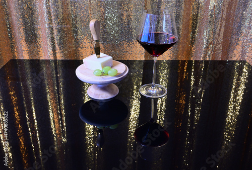 ein glas rotwein und hplzplatte mit dem parmigiano