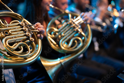 Close-up of a French horn in the hands of a musician during a brass band concert