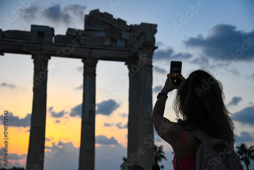 Touristen machen Fotos von antiken Säulen im Gegenlicht der Dämmerung