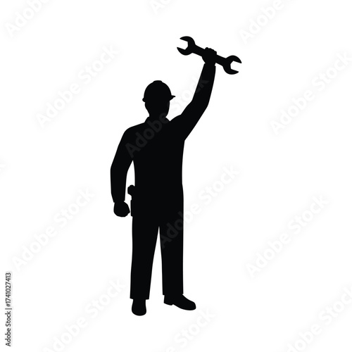 Silhouette of a construction worker triumphantly holding a wrench aloft