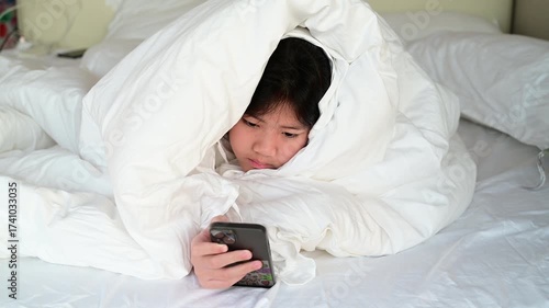 kid watching tablet on the bed, child addicted cartoon
