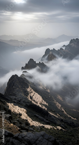 Dramatic Mountain Peaks Emerging Through Thick Clouds.