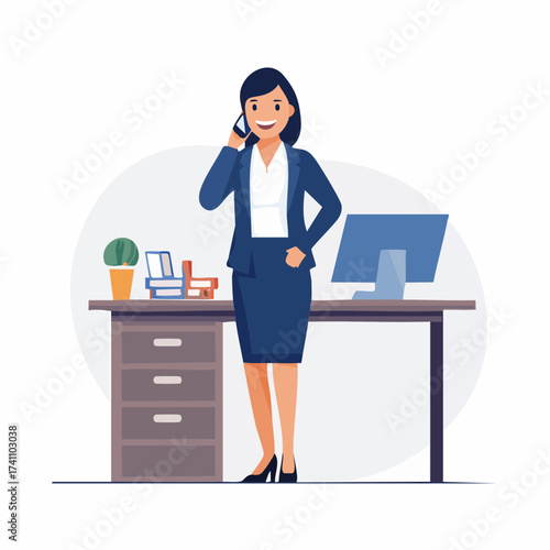 A professional businesswoman in a blue suit talking on the phone while standing confidently at her office desk with a computer and office supplies.