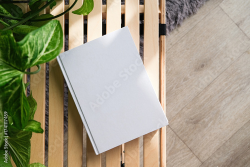 blank book mockup on decorative table with many green plants