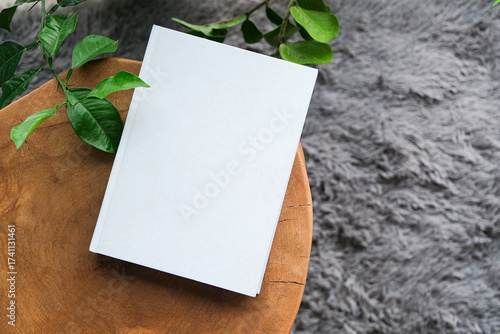 blank book mockup on decorative table with many green plants