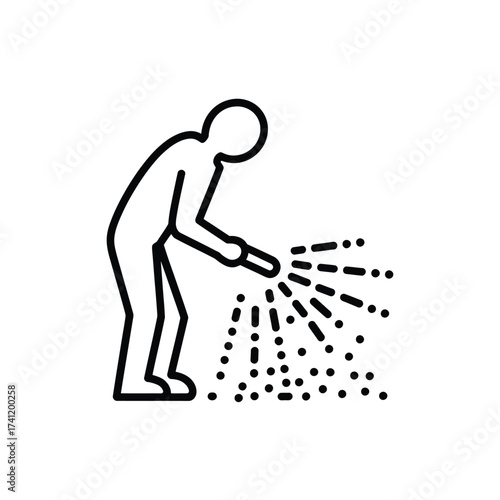 Person spraying granular material from a device onto the ground