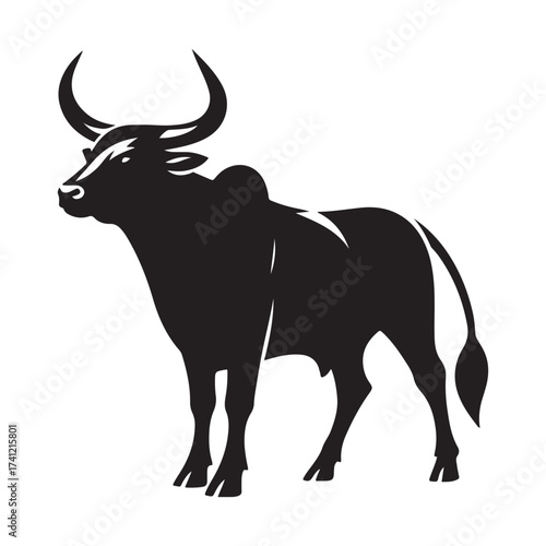 Silhouette of a majestic bull with prominent horns standing on a grassy field