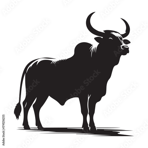 Silhouette of a majestic bull with prominent horns standing on a grassy field