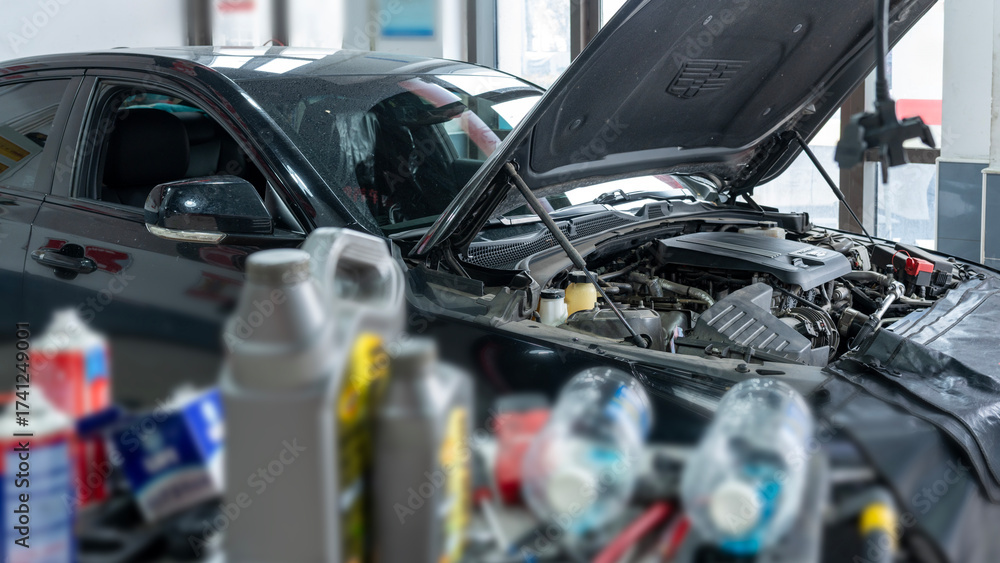 Fototapeta premium Car engine being inspected with various automotive fluids around