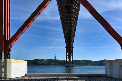 Bridge over river with monument on hillside in Lisbon Portugal