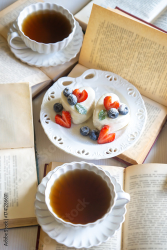 Red currant cake and a cup of aromatic tea in a porcelain cup on the table.