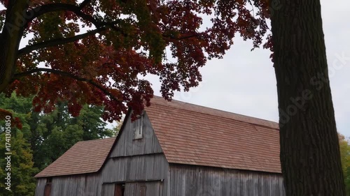Old wooden barn surrounded by sugar maple and swamp white oak trees with colorful autumn foliage