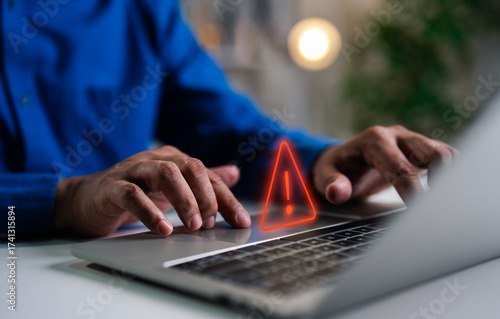 A Businessman working and using laptop computer with triangle caution warning sign for notification error and maintenance concept, network security, computer virus detected, personal data protection.