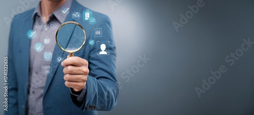 The businessman holding a magnifying glass exploring digital technology and insights.