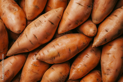 A solid background filled with wet earthy sweet potatoes with tapered ends