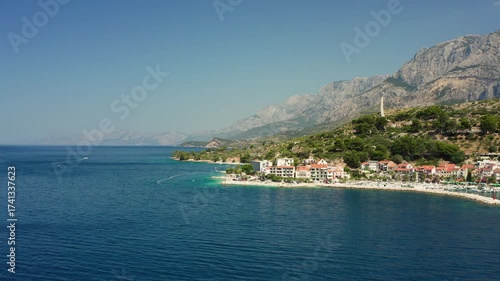 Wallpaper Mural A beautiful beach on the Adriatic coast of Croatia, with tourists swimming and sunbathing in the clear turquoise sea. A perfect summer holiday scene on the picturesque Podgora Riviera. Torontodigital.ca