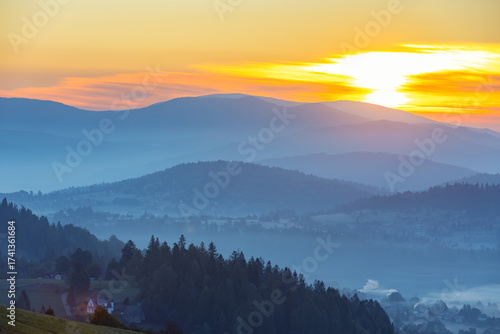 Fototapeta Naklejka Na Ścianę i Meble -  Jesienny widok na góry i spokojny krajobraz z mgłą i słońcem o świcie, Beskidy, Polska, tło lub fototapeta