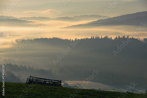 Jesienny widok na góry i spokojny krajobraz z mgłą i słońcem o świcie, Beskidy, Polska, tło lub fototapeta